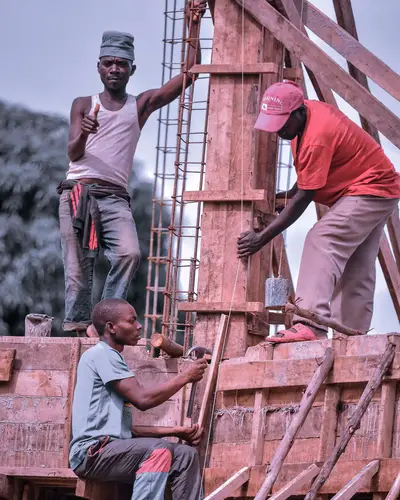 Des ouvriers montent un coffrage sur un chantier.