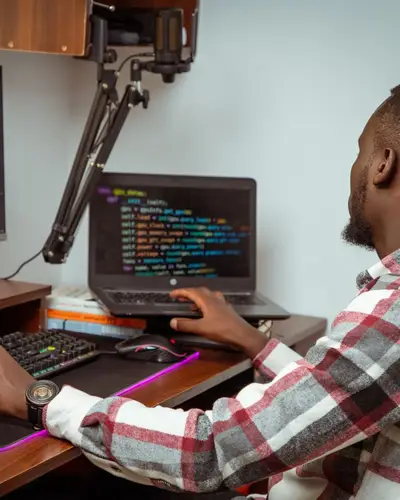 Un développeur écrit du code sur deux écrans.